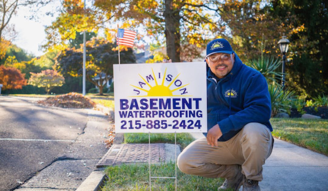 Jamison Basement Waterproofing technician with a service sign.