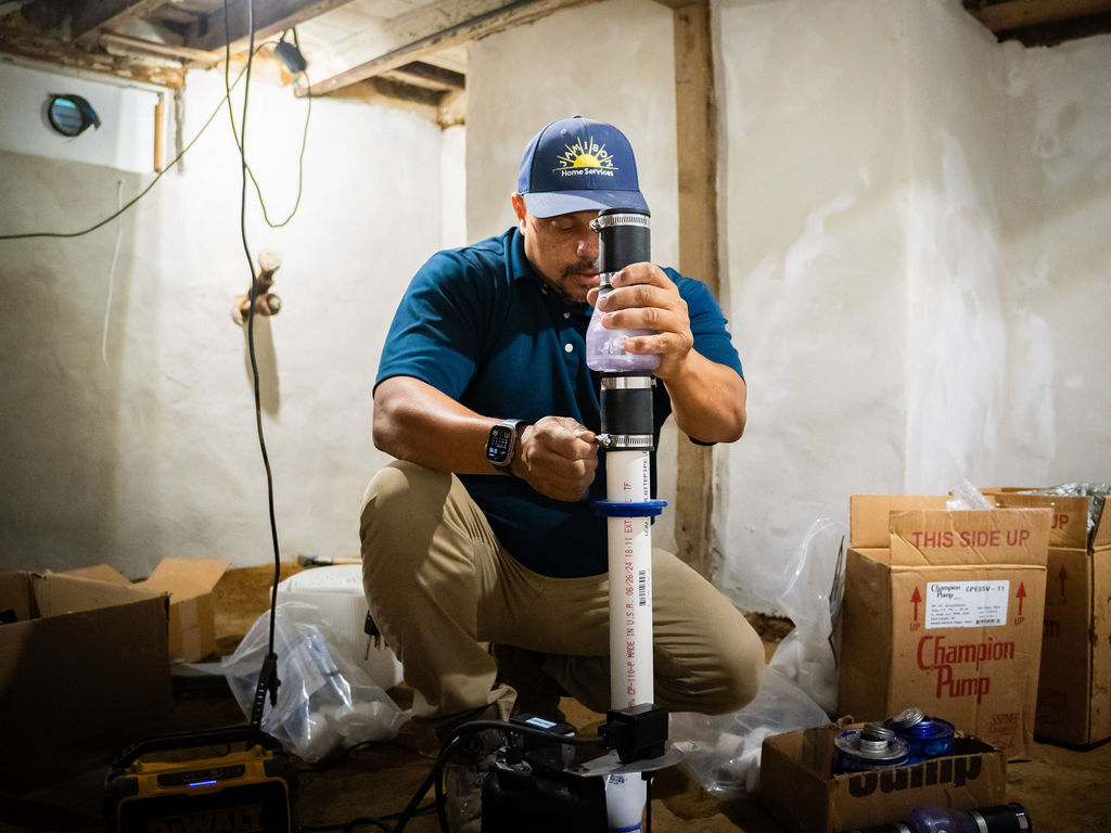 Technician installing sump pump in the basement